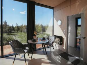 a dining room with a table and chairs and large windows at Juniper Minivilla Jacuzzi & Sauna in Söderby
