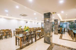 岑山的住宿－Maldives Hotel - FLC Sầm Sơn，一间在房间内配有桌椅的餐厅