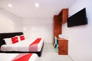 una camera con letto e TV a schermo piatto di OYO 1132 Azimaju Guesthouse a Malacca