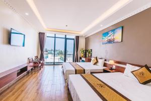 a hotel room with two beds and a large window at Maldives Hotel - FLC Sầm Sơn in Sầm Sơn