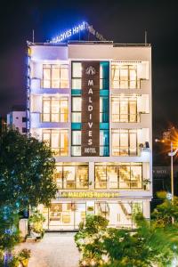 岑山的住宿－Maldives Hotel - FLC Sầm Sơn，一座白色的大建筑,上面有标志