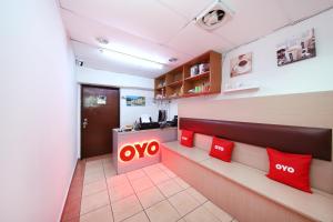 una hall di un ufficio con insegna ayno e cuscini rossi di OYO 1132 Azimaju Guesthouse a Malacca