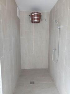 a bathroom with a shower with a bucket on the wall at Oázis Wellness Apartman2 in Hajdúszoboszló