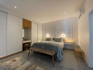 a bedroom with a bed and a bench in it at Klipmossel - Bek Bay in Paternoster