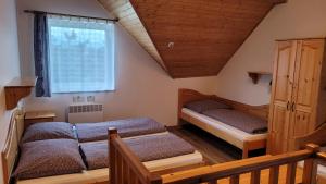 sypialnia z 2 łóżkami i oknem w obiekcie Aquapark Tatralandia BEST Apartman 335 Liptov w Liptowskim Mikulaszu