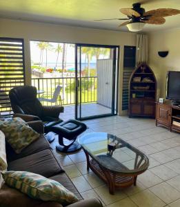a living room with a couch and a glass table at Ka Hale Kealoha in Kaunakakai