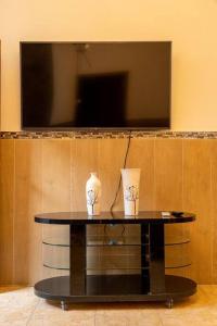 a black table with two vases on it with a television at Casa Privada en Siguatepeque in Siguatepeque