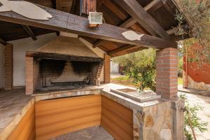 an outdoor kitchen with a brick fireplace in a backyard at Appartamento immerso nel verde in Domus de Maria