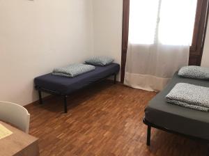 een kamer met 2 bedden en een raam bij Apartment 33A - No Bikes - Self check-in in Lugano