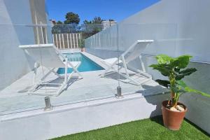 ein Paar Stühle auf einem Balkon mit Pool in der Unterkunft Hide&Sea Aroeira villa w/ heated pool at the Beach in Aroeira