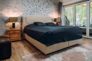 una camera da letto con un grande letto con una coperta blu di Villa Solitüde- Meierwik a Flensburgo