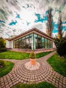 uma casa com um vaso de plantas em frente em Wolkendorf Bio Hotel & Spa em Brasov