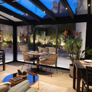 a conservatory with a table and chairs at Hôtel Rive Sud in Chinon