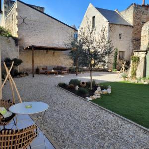 a garden with a patio with a table and chairs at Hôtel Rive Sud in Chinon