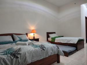 ein Schlafzimmer mit 2 Betten und einer Lampe auf einem Tisch in der Unterkunft Sofea Inn Bukit Merah - Suria A7727 in Kampong Selemat