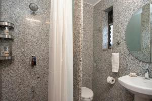 a bathroom with a shower and a toilet and a sink at ama stays & trails - Dulwich Park View in Panchgani +18 photos