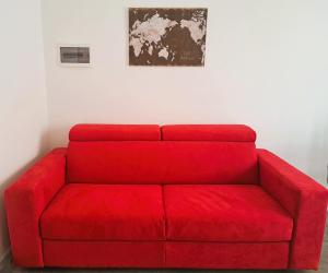 ein rotes Sofa in einem Zimmer mit einem Bild an der Wand in der Unterkunft LA PETITE MAISON in Agrate Brianza