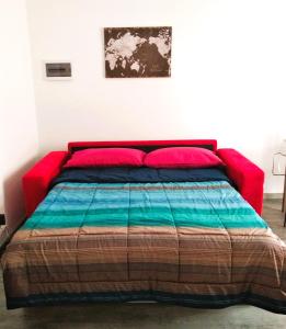 ein rotes Bett mit einer bunten Decke auf einem Zimmer in der Unterkunft LA PETITE MAISON in Agrate Brianza