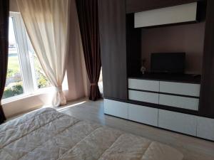 1 dormitorio con cama y vestidor con TV en Villa Paradise Garden, en Bliznatsi