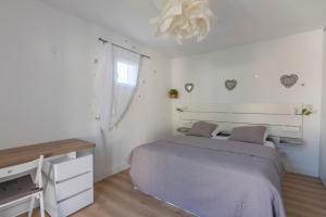 - une chambre avec un lit, un bureau et un lustre dans l'établissement La Petite Poule Rousse - Maison avec piscine, à Anduze