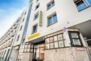 um edifício branco com um sinal amarelo em B&B Hotel München-Hbf em Munique