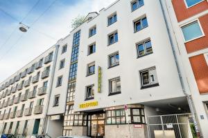 um edifício branco com um sinal amarelo em B&B Hotel München-Hbf em Munique