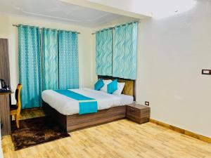 a bedroom with a bed with blue curtains at Staynest Mashobra with balcony- A peacefull stay in Shimla