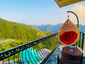 a chair on a balcony with a view of a mountain at Staynest Mashobra with balcony- A peacefull stay in Shimla