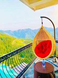 a hammock hanging from a balcony with a view of mountains at Staynest Mashobra with balcony- A peacefull stay in Shimla