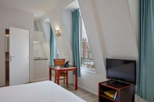 een slaapkamer met een bed, een tv en een raam bij Aparthotel Adagio Access Paris Philippe Auguste in Parijs