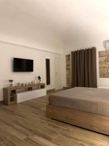 a bedroom with a bed and a flat screen tv at Il Moro in Carini