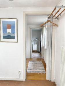 un pasillo con paredes blancas y una pintura en la pared en Retro cottage with garden in Torekov's best location, en Torekov