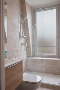 e bagno con servizi igienici e doccia in vetro. di Aparthotel Adagio Access Paris Philippe Auguste a Parigi