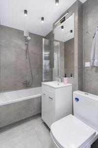 La salle de bains est pourvue de toilettes, d'un lavabo et d'une baignoire. dans l'établissement Cracow Best Rent Apartment Stachiewicza street, à Cracovie