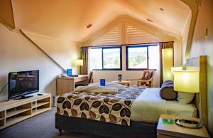 a bedroom with a large bed and a television at Highlander Hotel in Mount Hagen