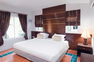 een slaapkamer met een groot wit bed en ramen bij Siray Green Resort in Phuket