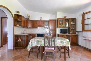 una cucina con mobili in legno e un tavolo con sedie di Casa Neda a Procchio