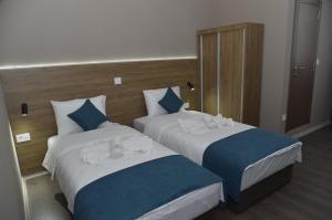 Dos camas en una habitación de hotel contigua en Harmony Hotel, en Kumanovo