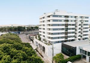 um edifício alto e branco ao lado de um parque de estacionamento em Rambla at Perry House em Brisbane