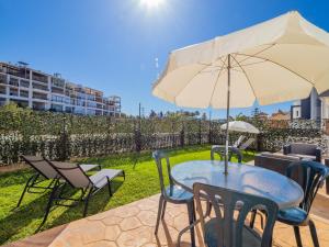 a patio with a table and chairs and an umbrella at Cubo's Hostal William's Sunny 4 with Breakfast in Torre de Benagalbón
