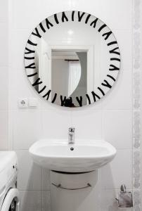 uma casa de banho com um lavatório branco e um espelho. em Апартаменты в центре Киева на Бессарабской Площади 7 em Kiev