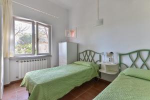 a bedroom with two beds and a window at Il Papavero in Procchio