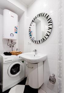uma casa de banho branca com uma máquina de lavar roupa e um espelho. em Апартаменты в центре Киева на Бессарабской Площади 7 em Kiev