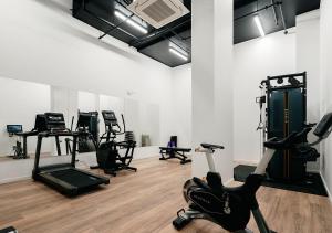 a room with several treadmills and exercise bikes in it at Rambla at Perry House in Brisbane