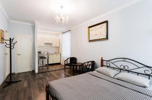 um quarto com uma cama, uma mesa e uma cozinha em Апартаменты в центре Киева на Бессарабской Площади 7 em Kiev