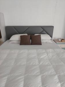 duże białe łóżko z 2 poduszkami w obiekcie HAPDESKO HOMESTAY w mieście Batam Center