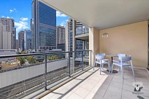 balcón con mesa, sillas y vistas al perfil urbano en KozyGuru | Haymarket | 2B Apt With Amazing View | Walk To Darling Harbour, en Sídney 7 fotos más