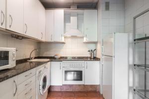 a kitchen with white cabinets and a washer and dryer at Central Market Beautiful Loft in Valencia