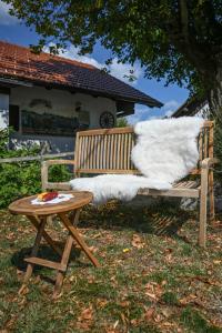 a wooden bench with a table and a white blanket at Holiday Farm Grofija in Ivančna Gorica