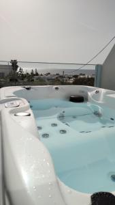 a bath tub filled with water with a view of the ocean at Blue Dream - Santorini in Kamari